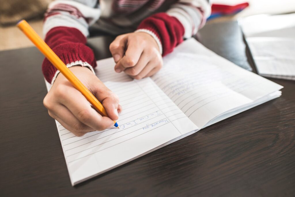 A child writing in a notepad.